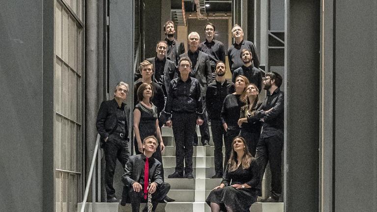 Das Ensemble hat sich auf einer Treppe in einem Konzerthaus versammelt Das Ensemble hat sich auf einer Treppe in einem Konzerthaus versammelt