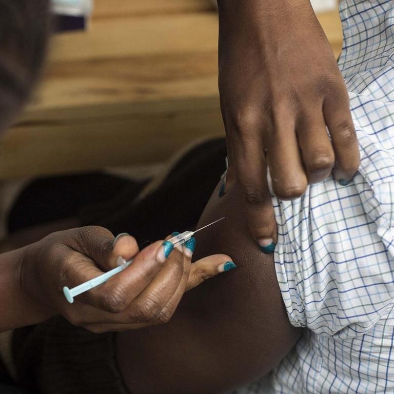 Einem Mann wird in Nairobi ein Corona-Impfstoff in den Arm gespritzt
