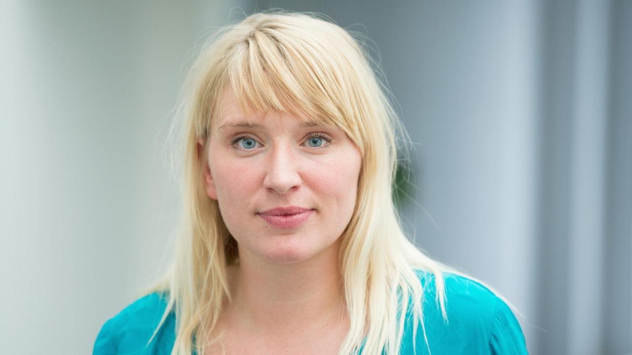 Die blonde Luise Amtsberg blickt vor einem gräulichen Hintergrund leicht lächelnd in die Kamera. Die blonde Luise Amtsberg blickt vor einem gräulichen Hintergrund leicht lächelnd in die Kamera.
