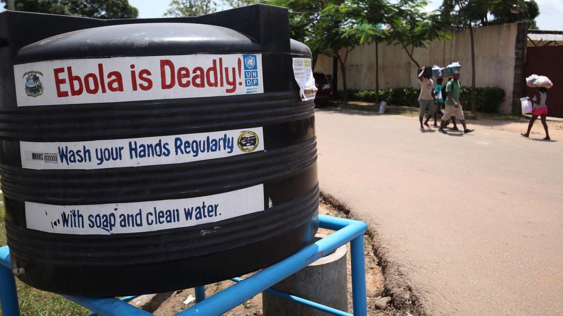 Ein schwarzer Tank auf einer Straße in Liberia mit der englischen Aufschrift "Ebola ist tödlich" und "Waschen Sie Ihre Hände" Ein schwarzer Tank auf einer Straße in Liberia mit der englischen Aufschrift "Ebola ist tödlich" und "Waschen Sie Ihre Hände"