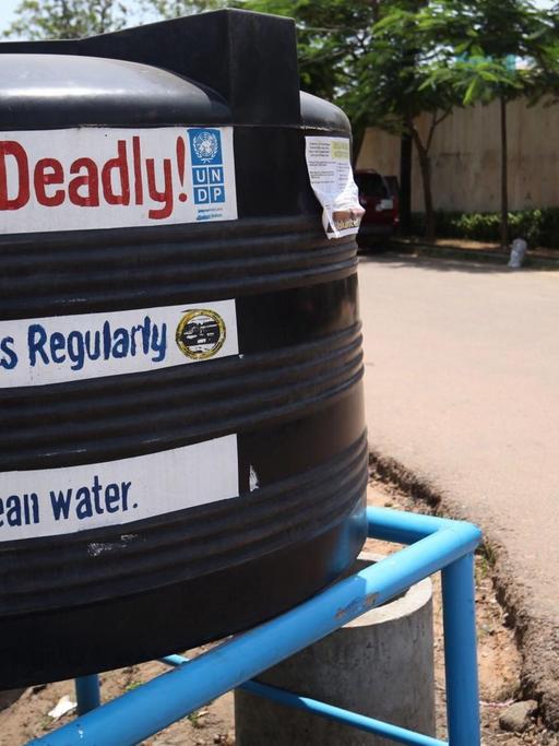 Ein schwarzer Tank auf einer Straße in Liberia mit der englischen Aufschrift "Ebola ist tödlich" und "Waschen Sie Ihre Hände"