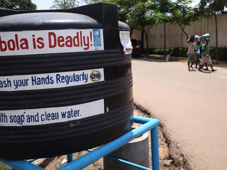 Ein schwarzer Tank auf einer Straße in Liberia mit der englischen Aufschrift "Ebola ist tödlich" und "Waschen Sie Ihre Hände"