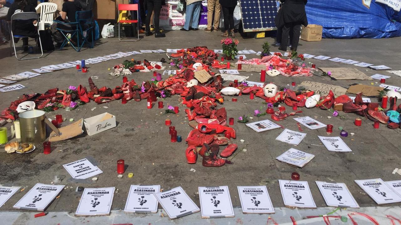 Hier sehen Sie das Camp der Frauen. Im Vordergrund das Friedenssymbol aus blutrotbemalten Frauenschuhen. Dazu eine Erinnerungskarte für jede der 27 ermordeten Opfer der letzten Monate. Im Hintergrund zwei der drei Zelte, in denen die Frauen hausen. Dazu ein Informationsstand für Interessierte. Dort werden Unterschriften gesammelt und Flyer verteilt sowie der 25 Punkte Plan, den die Frauen einfordern. Hier sehen Sie das Camp der Frauen. Im Vordergrund das Friedenssymbol aus blutrotbemalten Frauenschuhen. Dazu eine Erinnerungskarte für jede der 27 ermordeten Opfer der letzten Monate. Im Hintergrund zwei der drei Zelte, in denen die Frauen hausen. Dazu ein Informationsstand für Interessierte. Dort werden Unterschriften gesammelt und Flyer verteilt sowie der 25 Punkte Plan, den die Frauen einfordern.