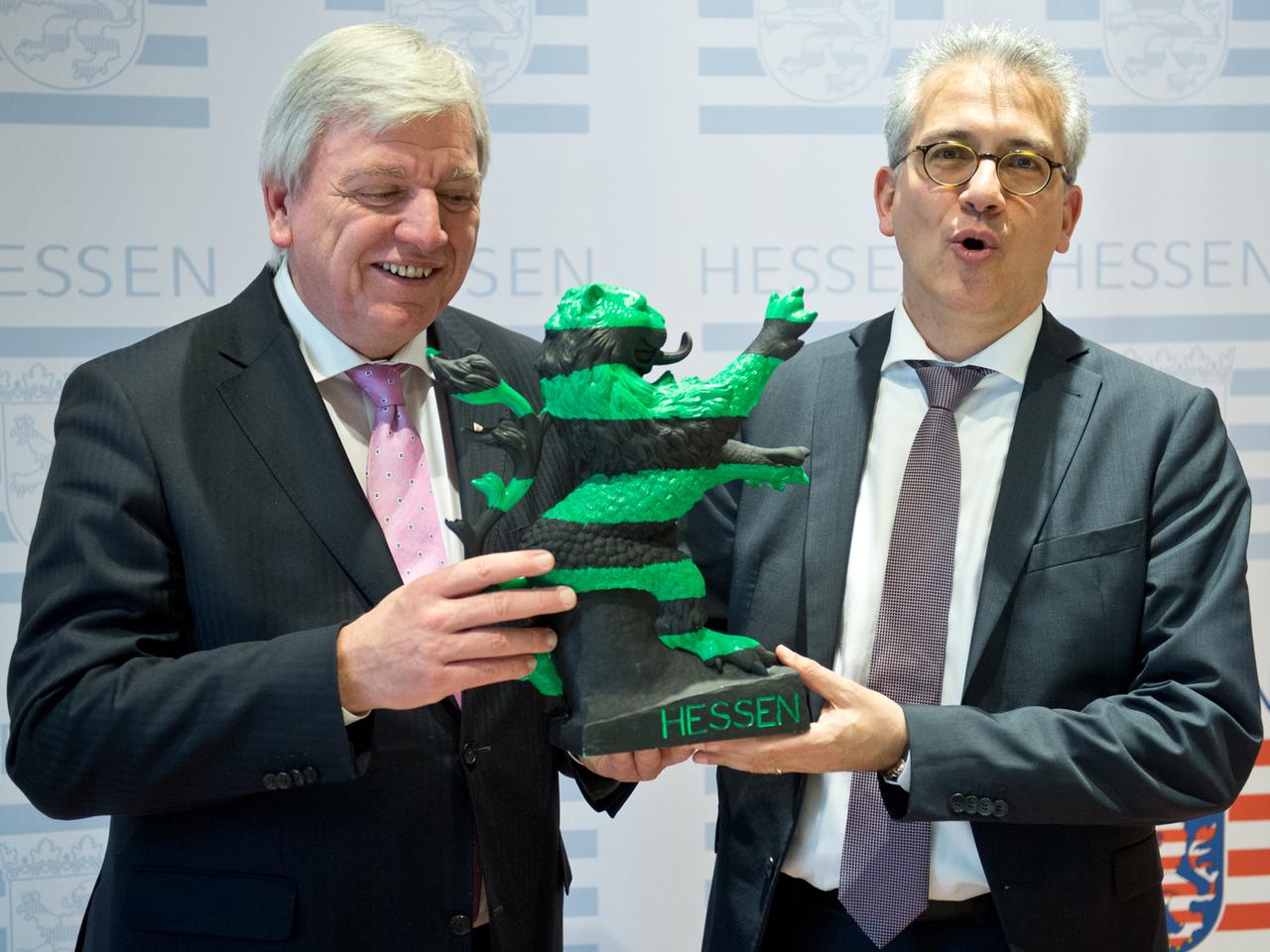 Der hessische Ministerpräsident Volker Bouffier (CDU) und sein Stellvertreter Tarek Al-Wazir (Die Grünen) hantieren mit einem schwarz-grünen "Hessenlöwen"