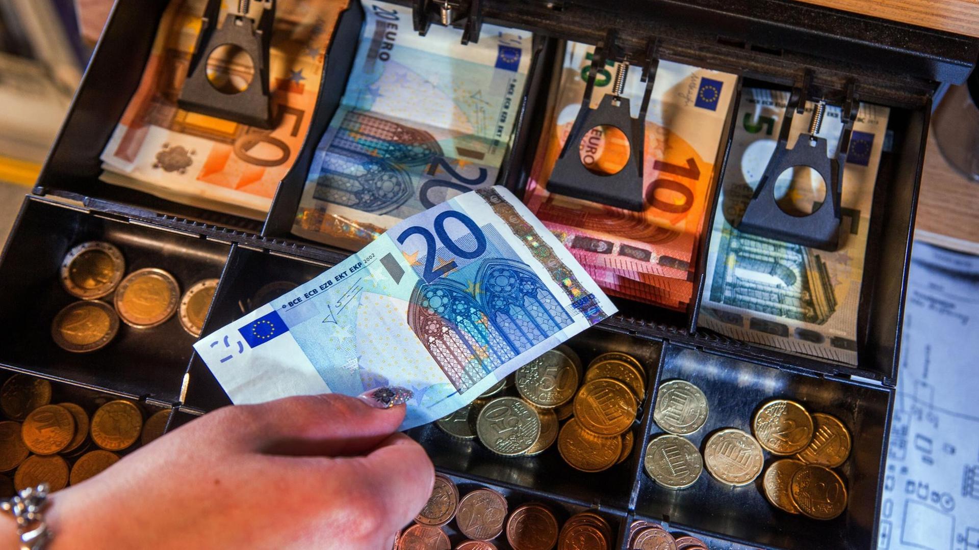 Scheine und Münzen liegen im Geldfach einer Ladenkasse. Scheine und Münzen liegen im Geldfach einer Ladenkasse.