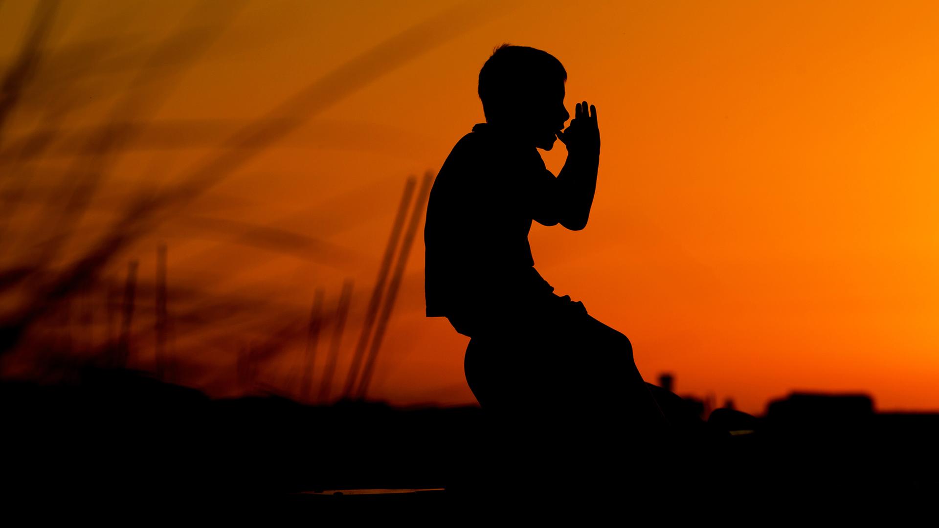 Ein Junge spielt im Sonnenuntergang auf Spielgeräten am Strand an der Ostseeküste Ein Junge spielt im Sonnenuntergang auf Spielgeräten am Strand an der Ostseeküste