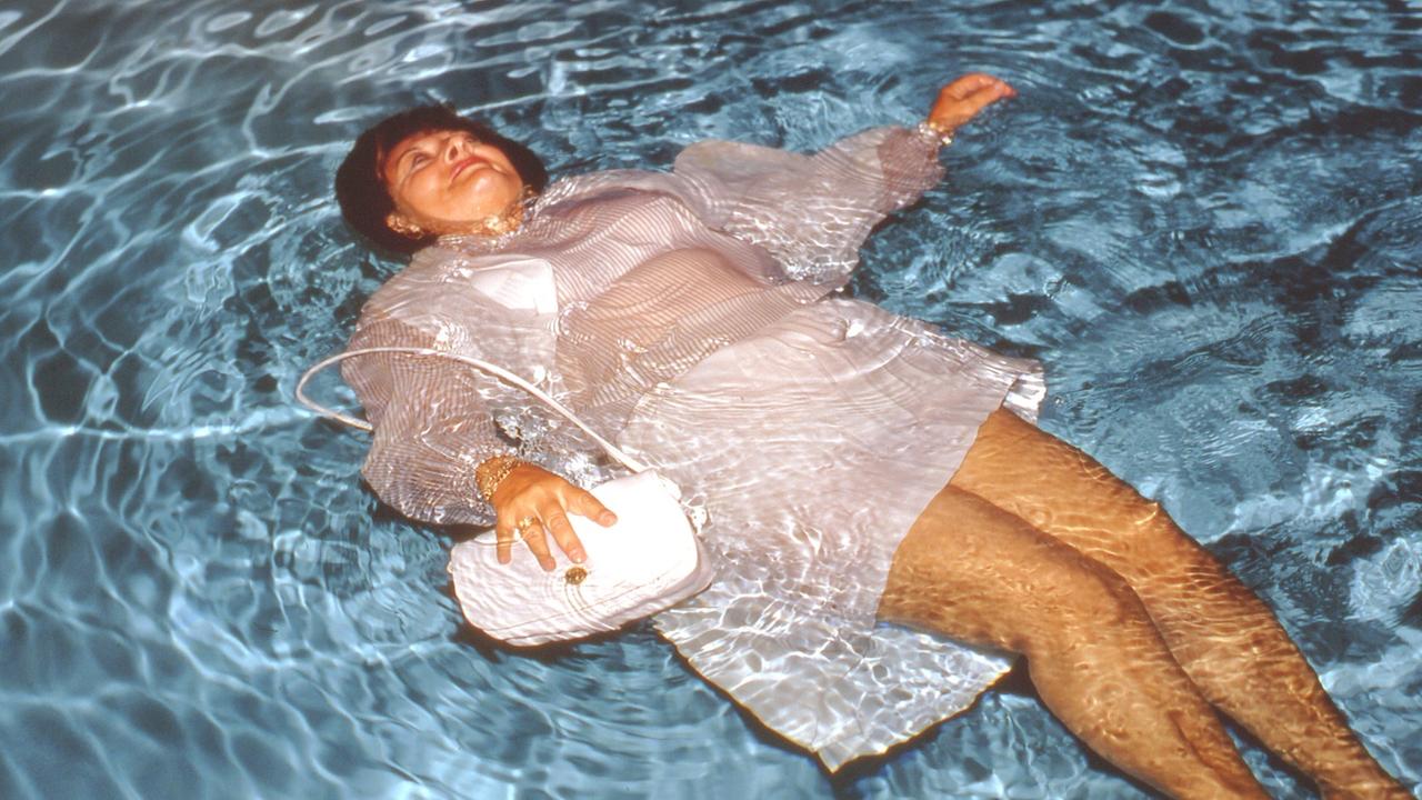 Ein Amateurfoto aus Erik Kessels Ausstellung - eine bekleidete Frau liegt in einem Swimming Pool (Bild: Erik Kessels)