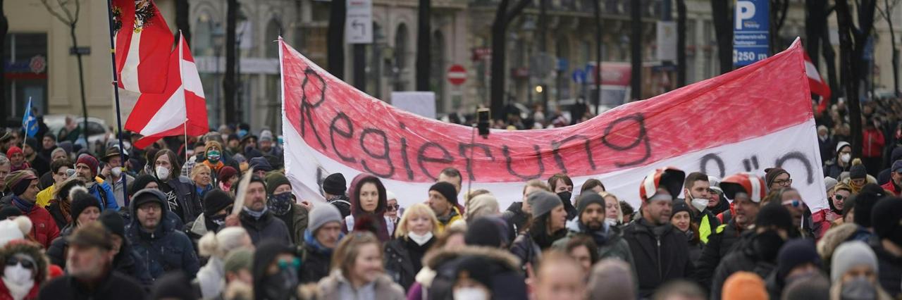Menschen gehen durch die Ringstraße in Wien, um gegen die Corona-Maßnahmen der Bundesregierung zu protestieren. + Menschen gehen durch die Ringstraße in Wien, um gegen die Corona-Maßnahmen der Bundesregierung zu protestieren. +