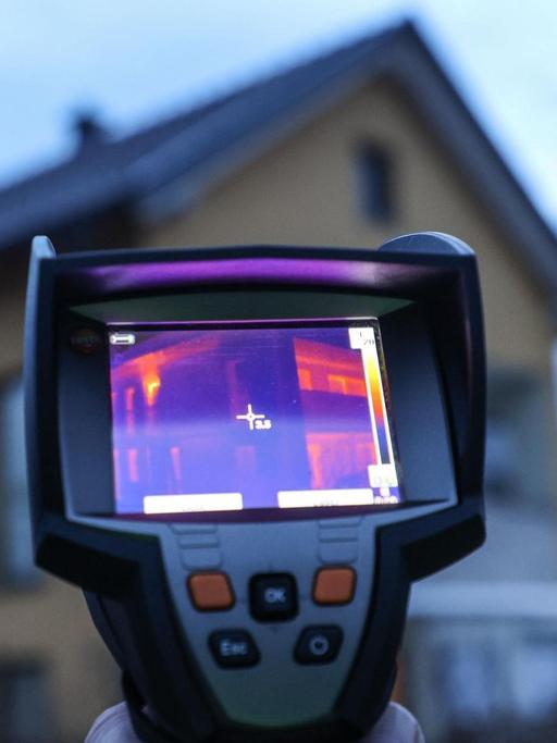 Eine Wärmebildkamera wird bei der Thermografiemessung eines Hauses eingesetzt.