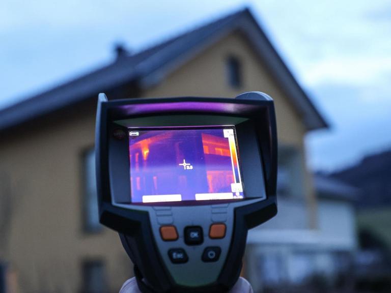 Eine Wärmebildkamera wird bei der Thermografiemessung eines Hauses eingesetzt.