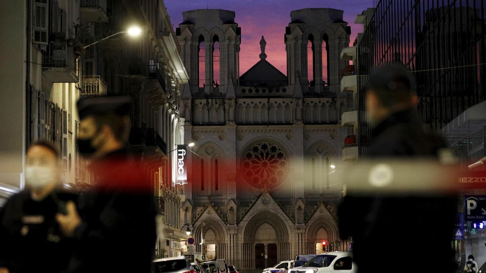 Die Basilika von Notre-Dame im Abendlicht. Außerdem Polizisten und ein Absperrband.