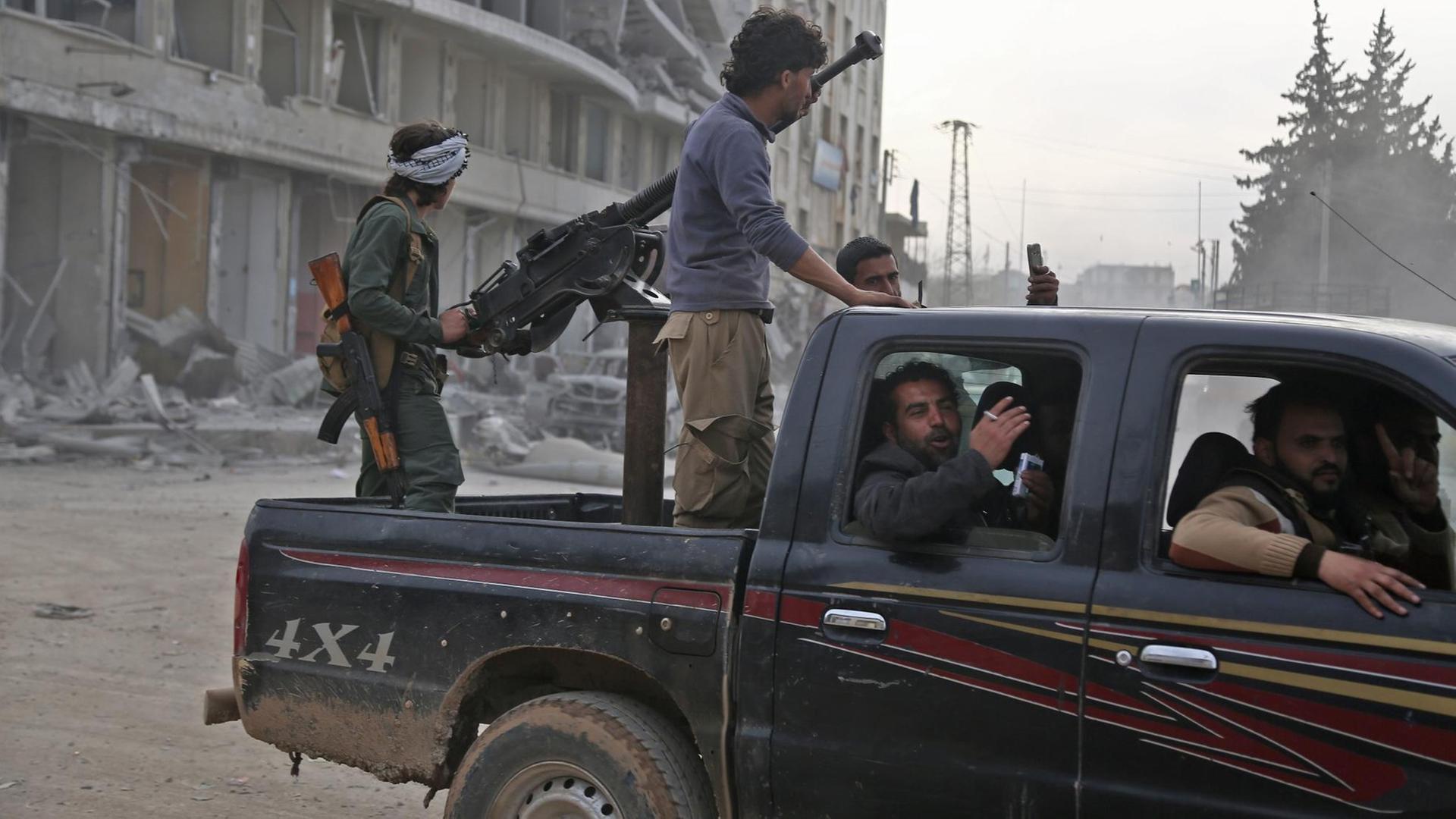 Syrisch-arabische Kämpfer in einem Fahrzeug nach Einnahme der syrischen Stadt Afrin am 18.März 2018. Nach einer von Ankara geführten zweimonatigen Offensive haben protürkische Rebellen die Stadt von der kurdischen Volksverteidigungseinheit YPG übernommen. Syrisch-arabische Kämpfer in einem Fahrzeug nach Einnahme der syrischen Stadt Afrin am 18.März 2018. Nach einer von Ankara geführten zweimonatigen Offensive haben protürkische Rebellen die Stadt von der kurdischen Volksverteidigungseinheit YPG übernommen.