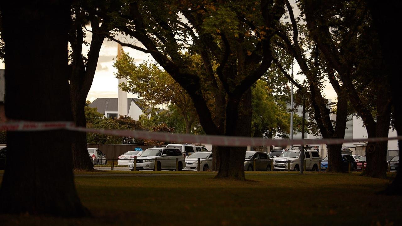 In einer Strasse hinter Bäumen stehen eine Reihe von Polizeiwagen, dahinter die Moschee. In einer Strasse hinter Bäumen stehen eine Reihe von Polizeiwagen, dahinter die Moschee.