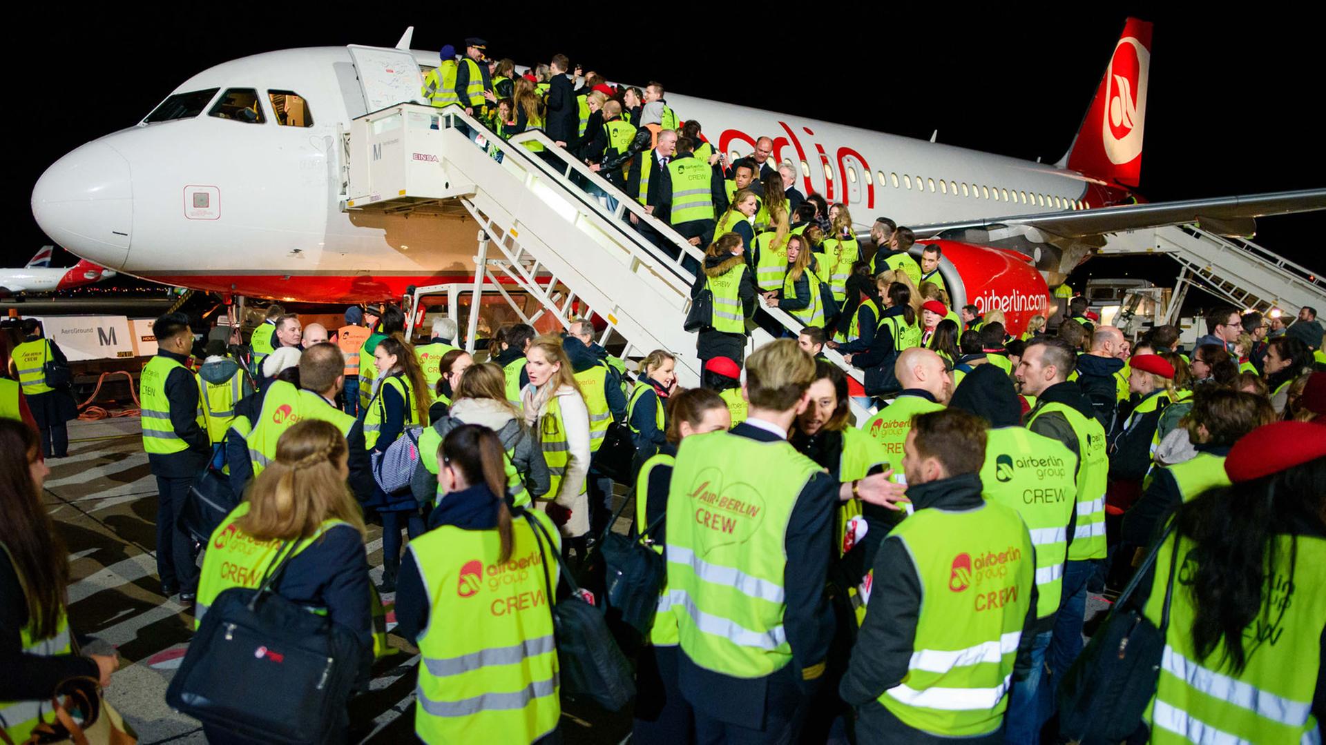 Mitarbeiter der Fluggesellschaft Air Berlin stehen am 27.10.2017 auf dem Vorfeld des Flughafen Berlin-Tegel nach der Landung der letzten Maschine der Airline auf einer Fluggasttreppe. Mitarbeiter der Fluggesellschaft Air Berlin stehen am 27.10.2017 auf dem Vorfeld des Flughafen Berlin-Tegel nach der Landung der letzten Maschine der Airline auf einer Fluggasttreppe.