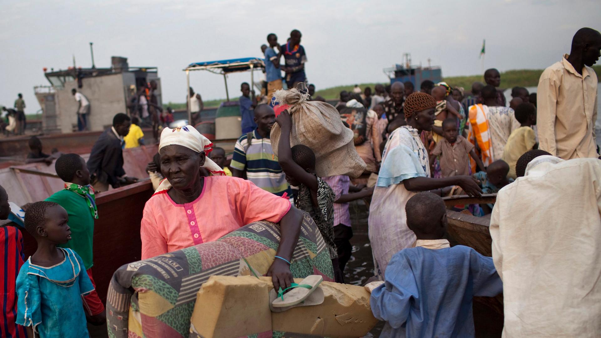 Südsudaneische Flüchtlinge (Volksgruppe der Dinkas) sind mit ihren Habseligkeiten unterwegs.