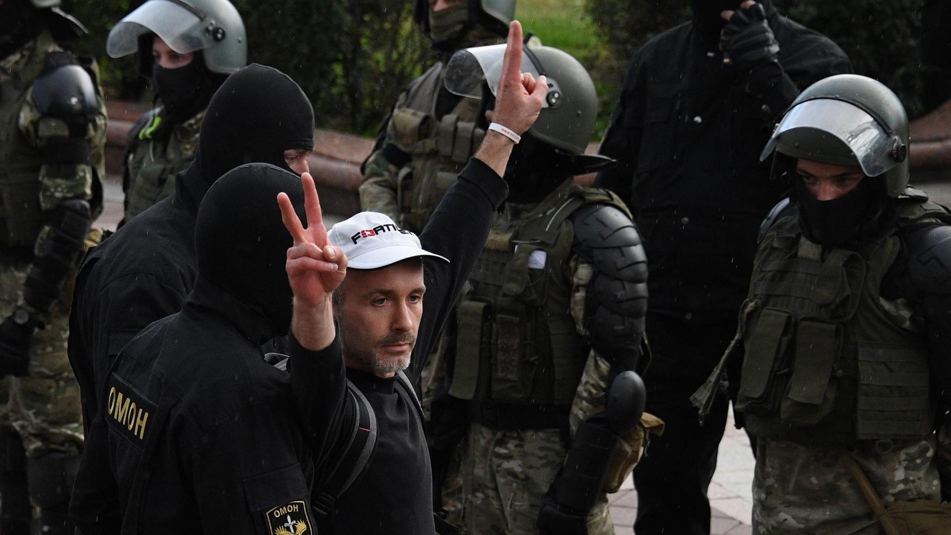 Polizisten verhaften in Minsk einen Demonstranten der die Hand zum Victory-Gruß erhebt Polizisten verhaften in Minsk einen Demonstranten der die Hand zum Victory-Gruß erhebt