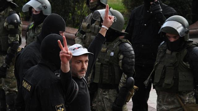Polizisten verhaften in Minsk einen Demonstranten der die Hand zum Victory-Gruß erhebt