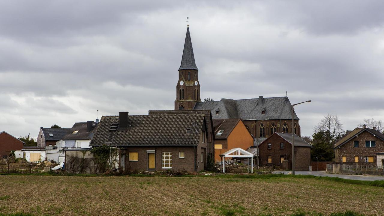 Verlasse Häuser im Geisterdorf Manheim, über deren Dächern ein Kirchturm aufragt. Verlasse Häuser im Geisterdorf Manheim, über deren Dächern ein Kirchturm aufragt.