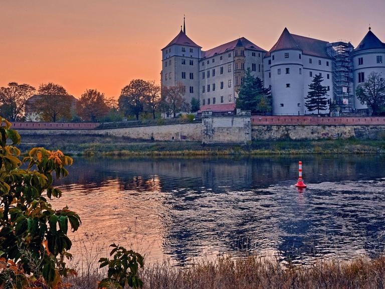 Das Schloss Hartenfels im Sonnenuntergang am Ufer der Elbe in Torgau.