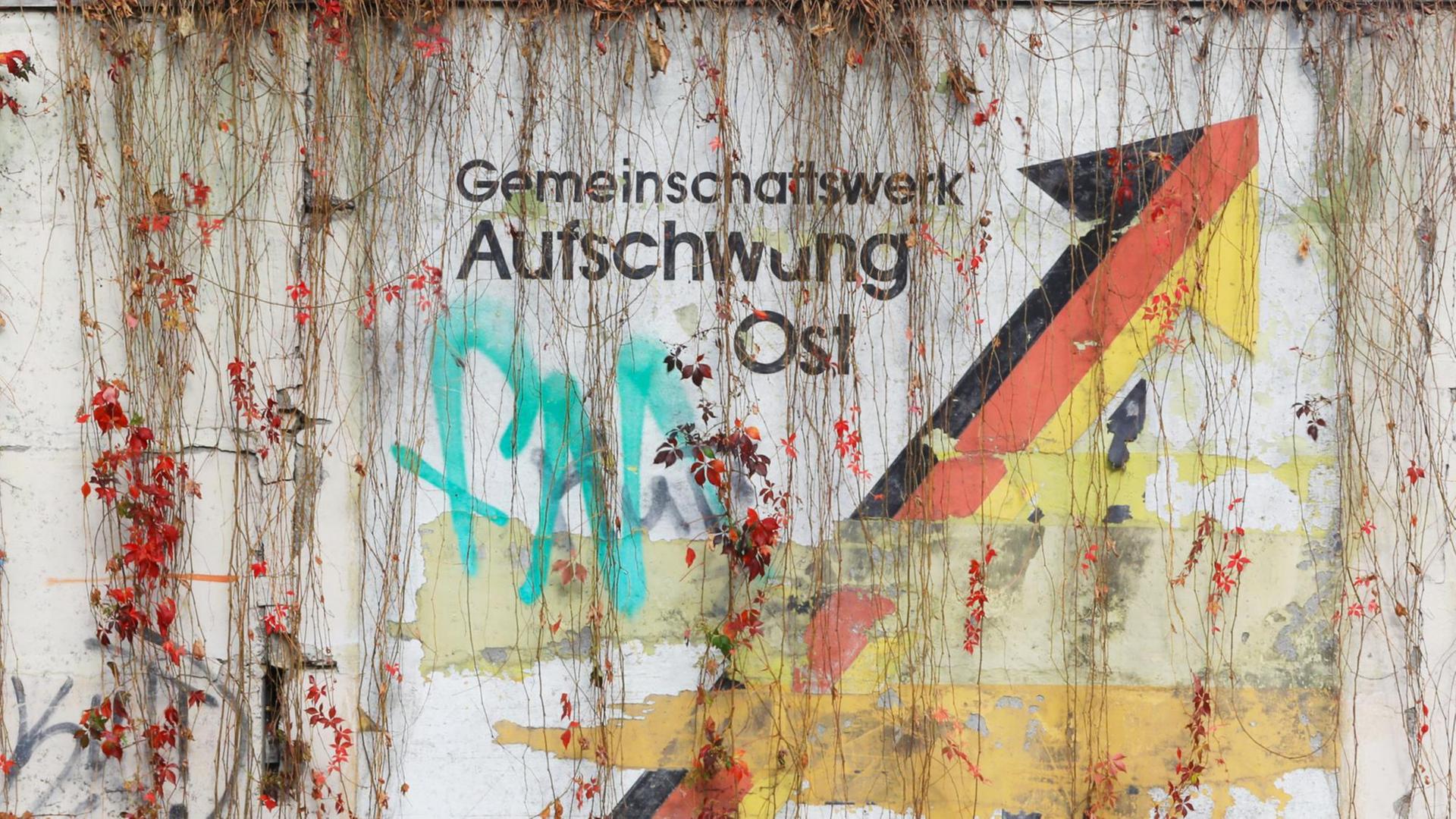 An einer Schallschutzwand prangt der verwitterte Schriftzug "Gemeinschaftswerk Aufschwung Ost". An einer Schallschutzwand prangt der verwitterte Schriftzug "Gemeinschaftswerk Aufschwung Ost".