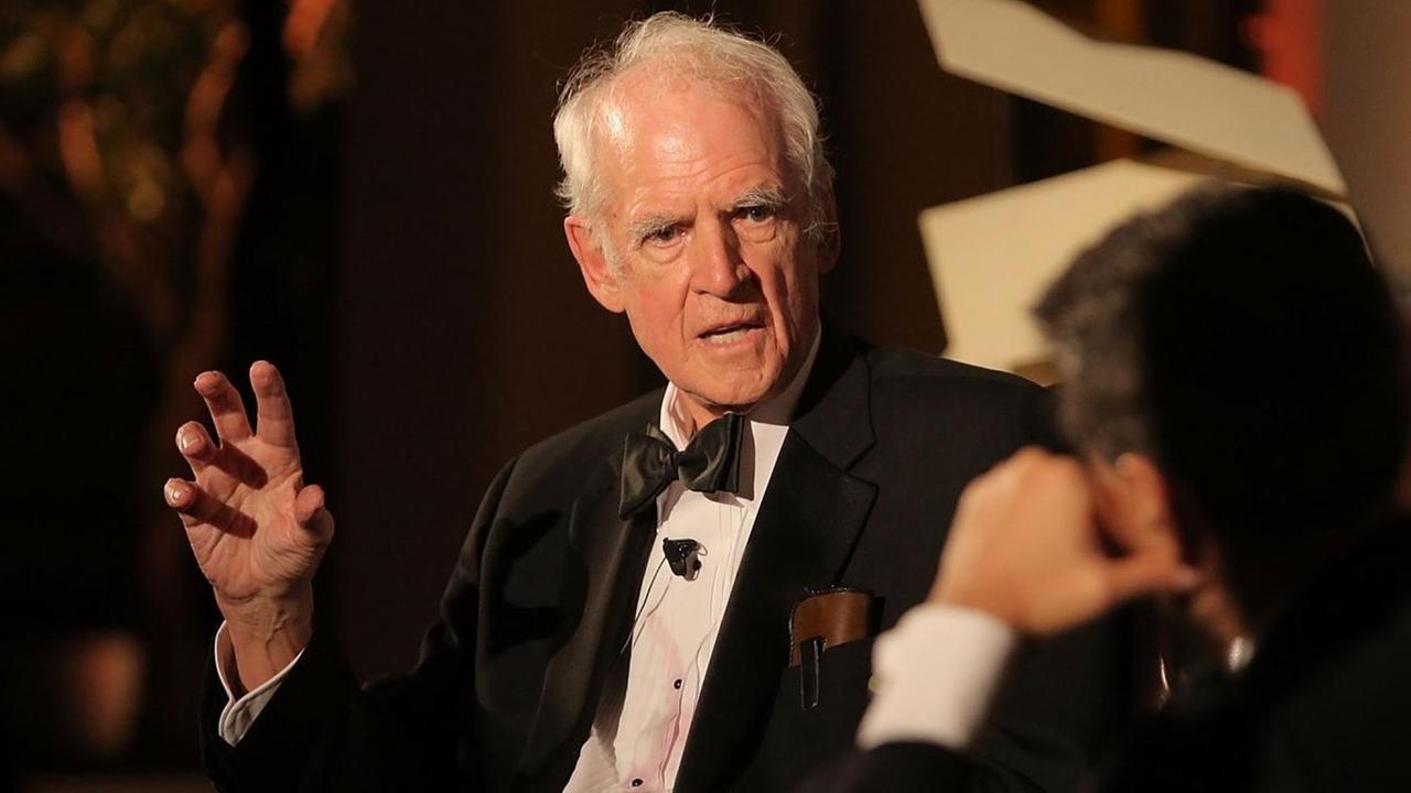 Charles Taylor sitzt auf einer Bühne und unterhält sich mit einem Moderator. Charles Taylor sitzt auf einer Bühne und unterhält sich mit einem Moderator.