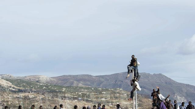 Afrikanische Flüchtlinge versuchen, den Grenzzaun zur spanischen Exklave Melilla zu überwinden.
