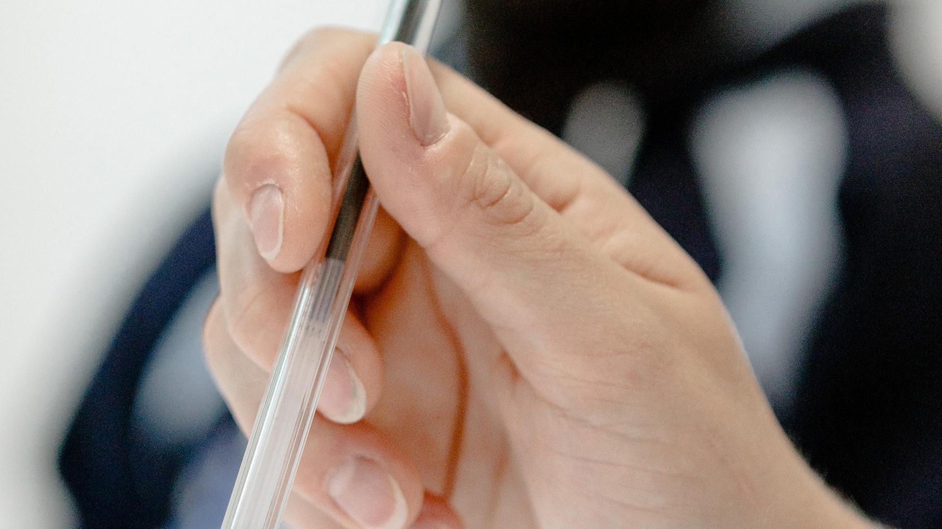 Eine Frau hält einen Stift in der Hand. Eine Frau hält einen Stift in der Hand.