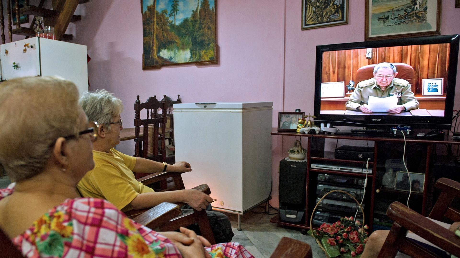 Mehrere kubanische Frauen sitzen vor dem Fernseher, in dem Staatspräsident Raúl Castro bei einer Ansprache zu sehen ist. Mehrere kubanische Frauen sitzen vor dem Fernseher, in dem Staatspräsident Raúl Castro bei einer Ansprache zu sehen ist.