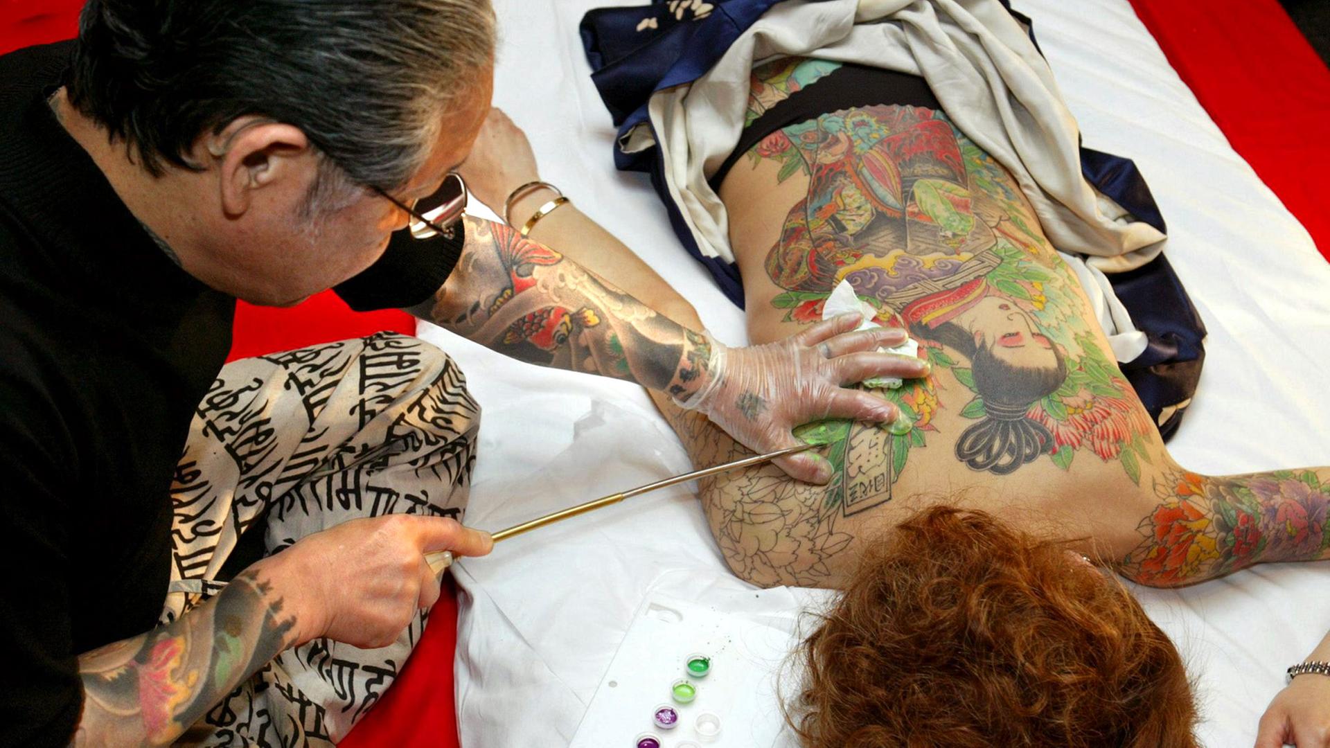 Der japanische Tattoo-Künstler Horiyoshi San Daime bei der Arbeit Der japanische Tattoo-Künstler Horiyoshi San Daime bei der Arbeit