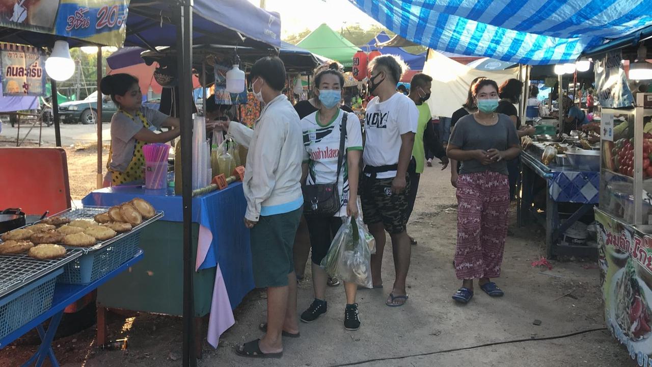 Menschen kaufen auf einem Mark in Thailand ein.
