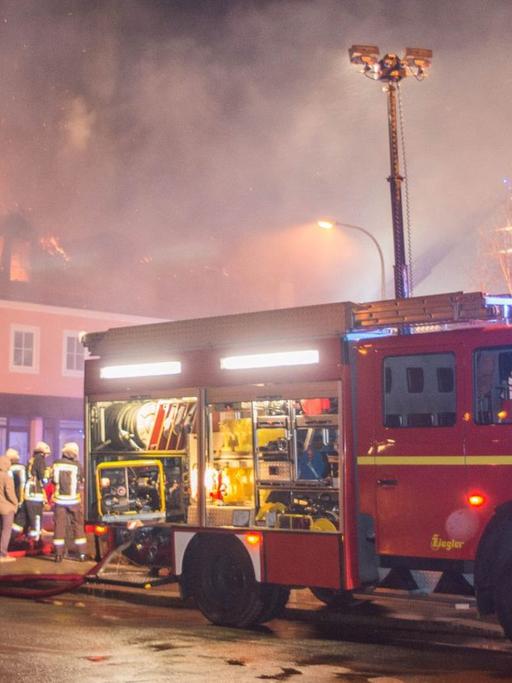 Ein Feuerwehrfahrzeug steht am 21.02.2016 in Bautzen (Sachsen) vor einem brennenden Haus. In einer geplanten Flüchtlingsunterkunft war in der Nacht zu Sonntag ein Feuer ausgebrochen. Foto: Rico Löb/dpa