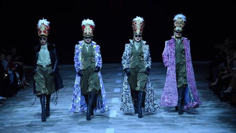 Vier Models laufen mit Militärmänteln bei der China Fashion Week am 25. März 2019 in Peking über den Laufsteg, dabei tragen sie die neue Kollektion des Designers Hu Sheguang.