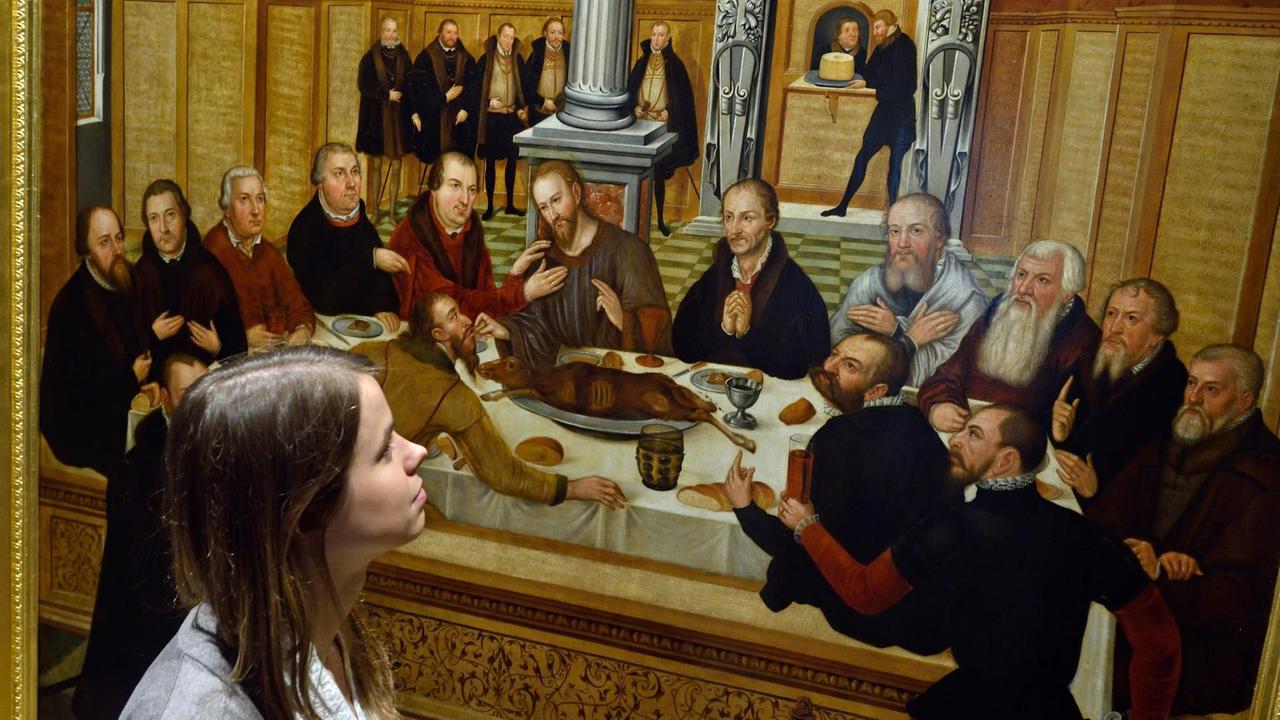 Die Besucherin einer Vorbesichtigung betrachtet am 25.06.2015 in der Ausstellung «Lucas Cranach der Jüngere - Entdeckung eines Meisters» im Augusteum in Wittenberg (Sachsen-Anhalt) das Gemälde "Abendmahl" (nach 1565), das Lucas Cranach dem Jüngeren zugeschrieben wird. Die Besucherin einer Vorbesichtigung betrachtet am 25.06.2015 in der Ausstellung «Lucas Cranach der Jüngere - Entdeckung eines Meisters» im Augusteum in Wittenberg (Sachsen-Anhalt) das Gemälde "Abendmahl" (nach 1565), das Lucas Cranach dem Jüngeren zugeschrieben wird.