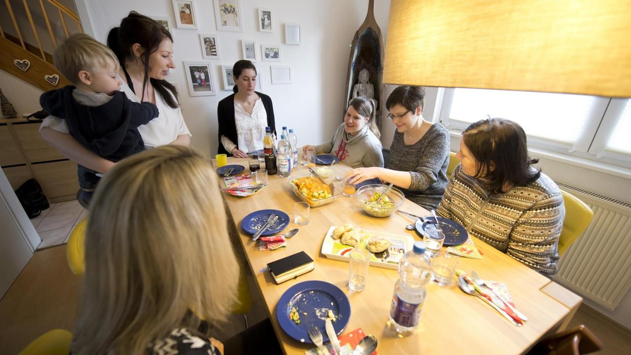 Frauen sitzen während einer Verkaufsparty beim Essen um einen Tisch.
Frauen sitzen während einer Verkaufsparty beim Essen um einen Tisch.