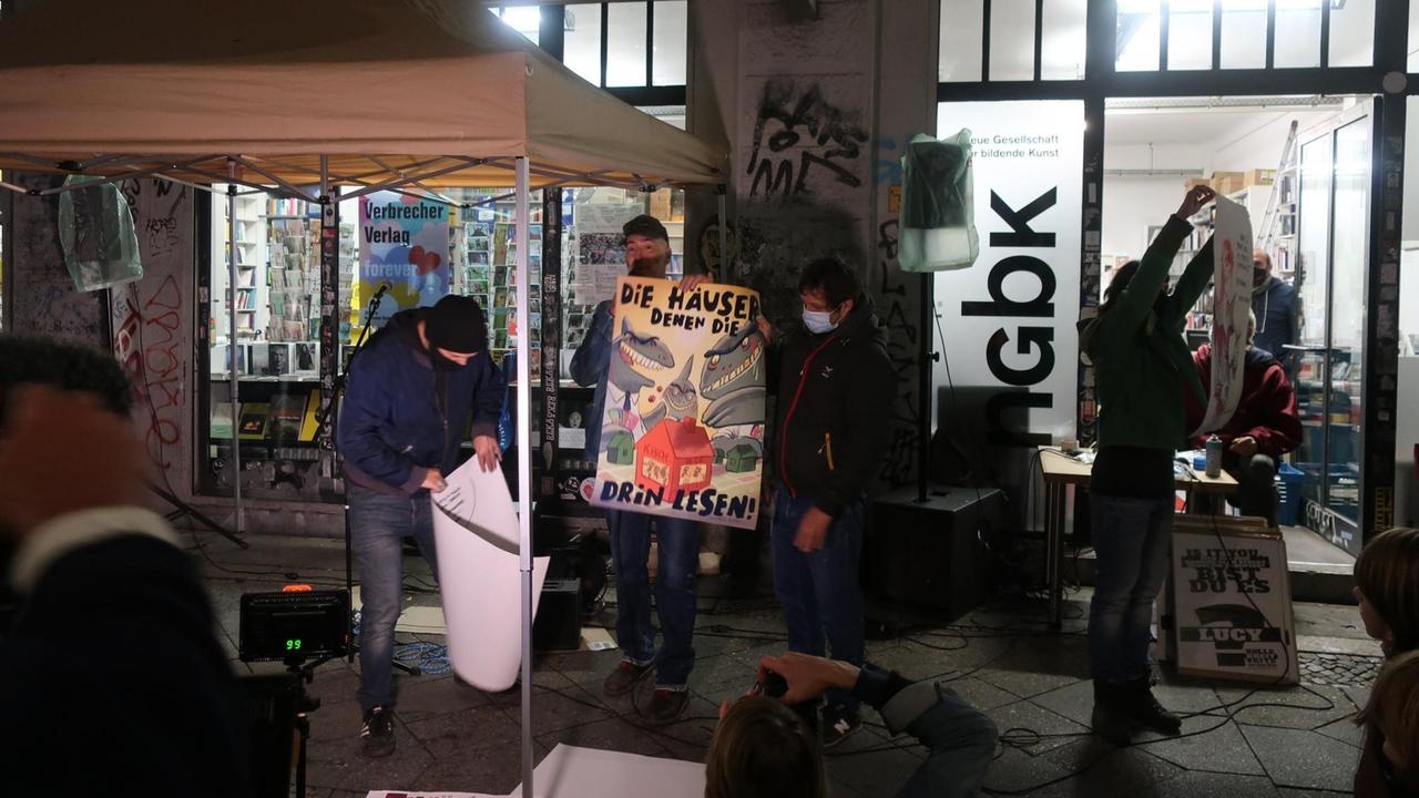Phil hält vor dem Kisch ein Plakat mit der Aufschrift: "Die Häuser denen, die drin lesen!" Phil hält vor dem Kisch ein Plakat mit der Aufschrift: "Die Häuser denen, die drin lesen!"