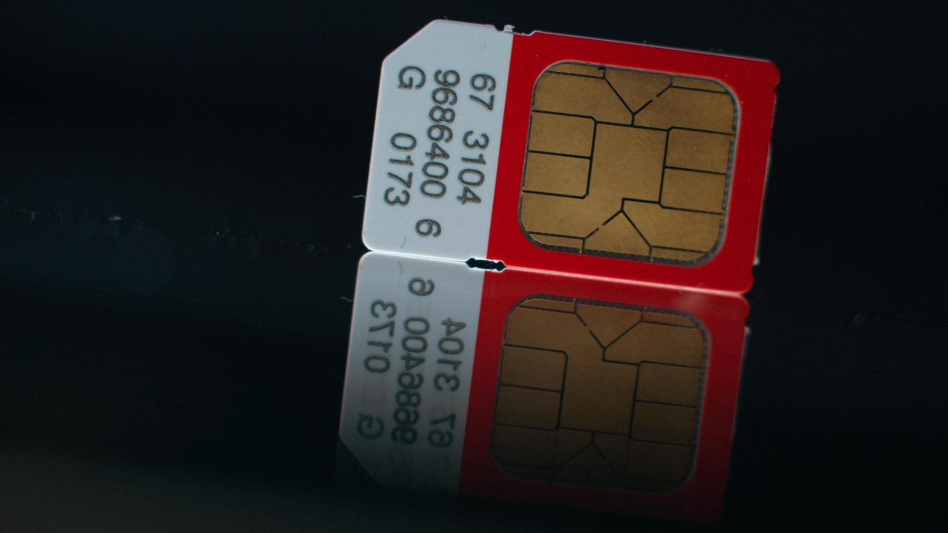 Eine SIM-Karte liegt auf einem Spiegel. Eine SIM-Karte liegt auf einem Spiegel.
