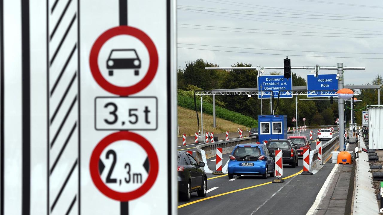 Autos fahren am 19.06.2016 in Leverkusen (Nordrhein-Westfalen) durch eine bereits teilweise aufgebaute Schrankenanlage. Die ersten Schranken für die Lkw-Sperren an der maroden Leverkusener Rheinbrücke stehen und sollen bald ihre Arbeit aufnehmen. Die Schrankenanlage soll verhindern, dass Fahrzeuge mit mehr als 3,5 Tonnen Gewicht trotz Verbots über die altersschwache Brücke fahren können. Autos fahren am 19.06.2016 in Leverkusen (Nordrhein-Westfalen) durch eine bereits teilweise aufgebaute Schrankenanlage. Die ersten Schranken für die Lkw-Sperren an der maroden Leverkusener Rheinbrücke stehen und sollen bald ihre Arbeit aufnehmen. Die Schrankenanlage soll verhindern, dass Fahrzeuge mit mehr als 3,5 Tonnen Gewicht trotz Verbots über die altersschwache Brücke fahren können.