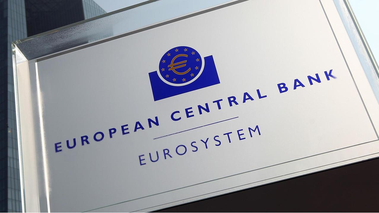 Ein Schild mit dem Eurozeichen im Kreis von 12 gelben Sternen, darunter zweizeilig "European Central Bank" und "Eurosystem"