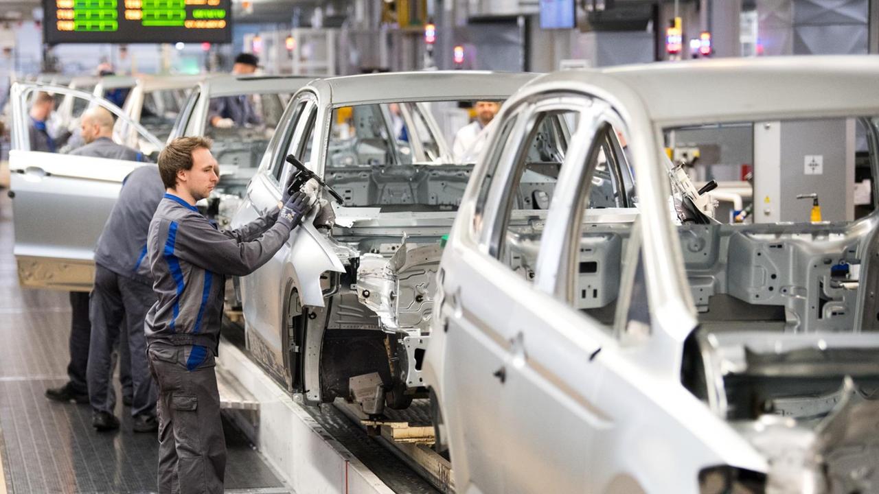 Das Bild zeigt einen Arbeiter an einem Montageband in einem VW-Werk. Das Bild zeigt einen Arbeiter an einem Montageband in einem VW-Werk.