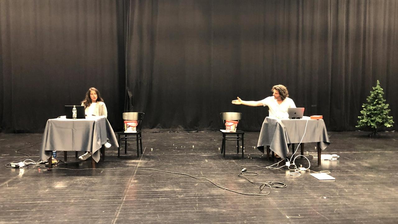 Die Schauspielerin Johanna Steinhauser und ihr Kollege Rasmus Max Wirth sitzen in zwei Meter Abstand auf der Bühne im digitalen Theatersaal in der Nürnberger Tafelhalle. Vor ihnen stehen Tische, darauf Laptops mit Webcam. Die Schauspielerin Johanna Steinhauser und ihr Kollege Rasmus Max Wirth sitzen in zwei Meter Abstand auf der Bühne im digitalen Theatersaal in der Nürnberger Tafelhalle. Vor ihnen stehen Tische, darauf Laptops mit Webcam.