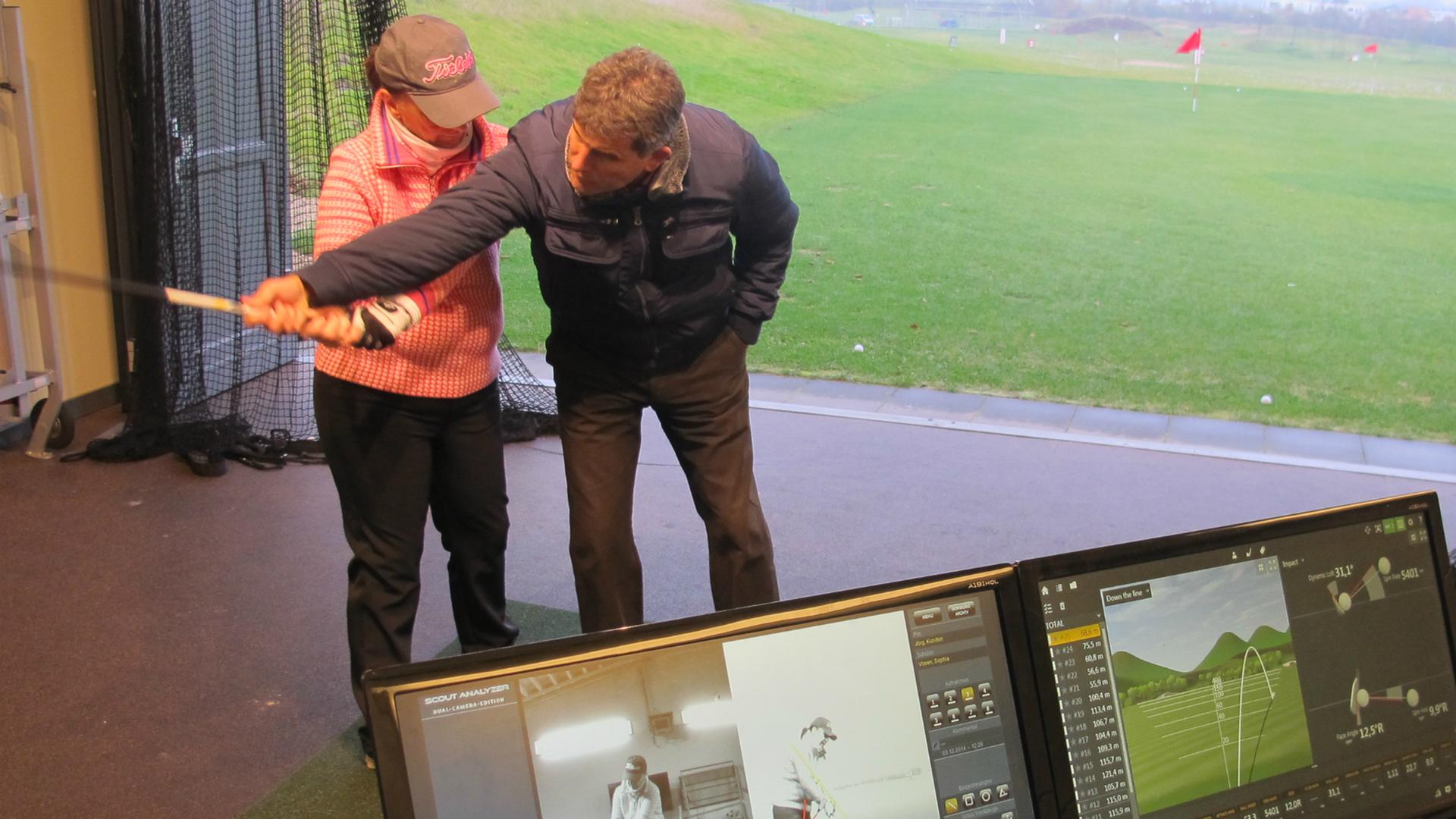 Golftrainer Jörg Fronczak gibt auf der Driving Range Instruktionen.