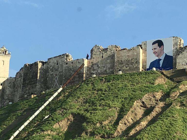 Eine Stadtansicht auf Aleppo mit einem großen Plakat des Staatspräsidenten Assad.