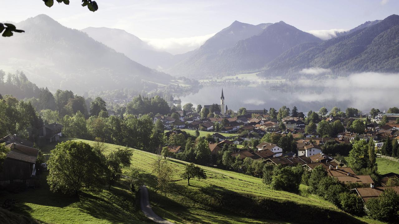 Morgennebel über Landschaft und Ort am Schliersee in Oberbayern