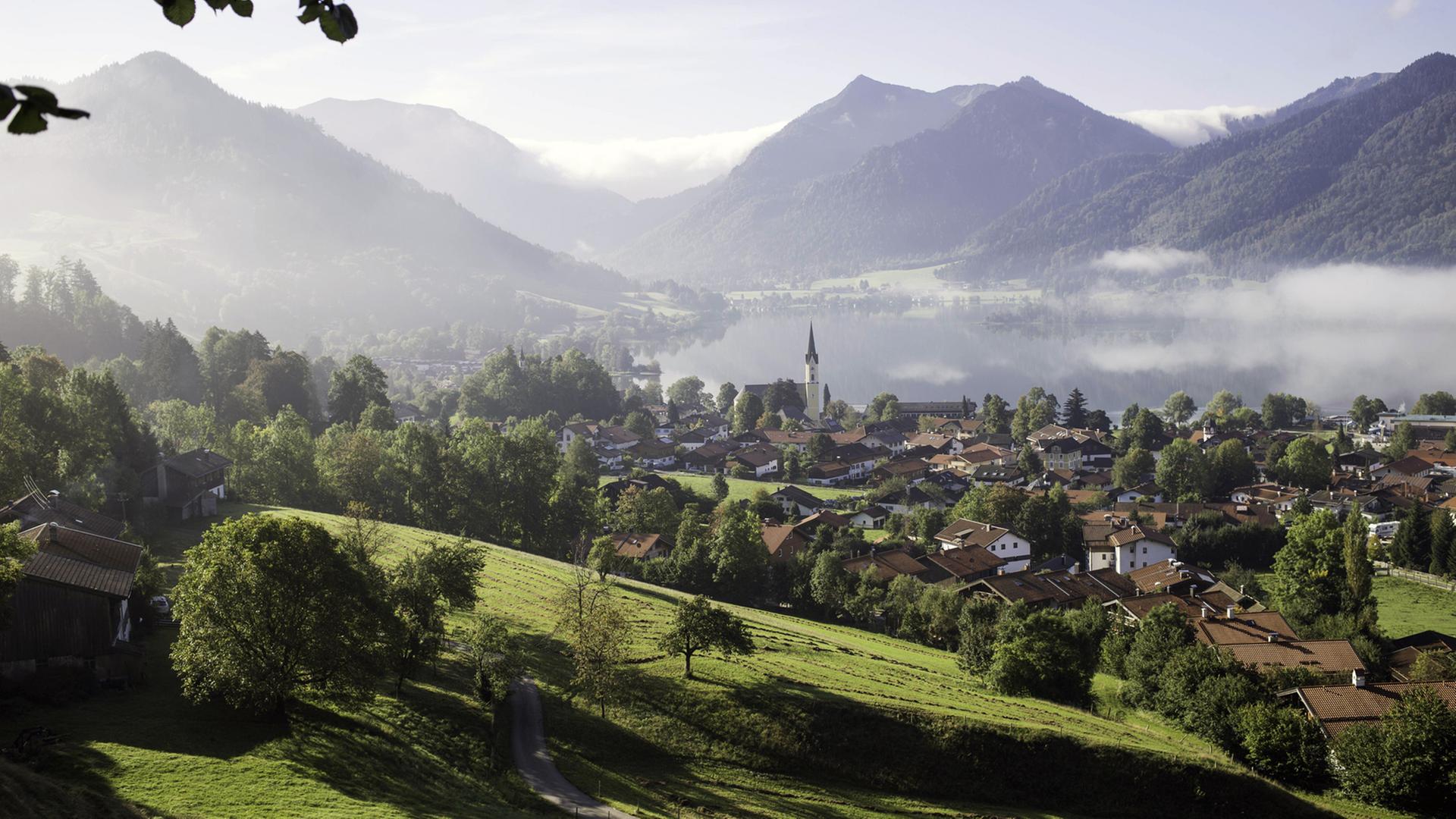 Morgennebel über Landschaft und Ort am Rande der Berge Morgennebel über Landschaft und Ort am Rande der Berge