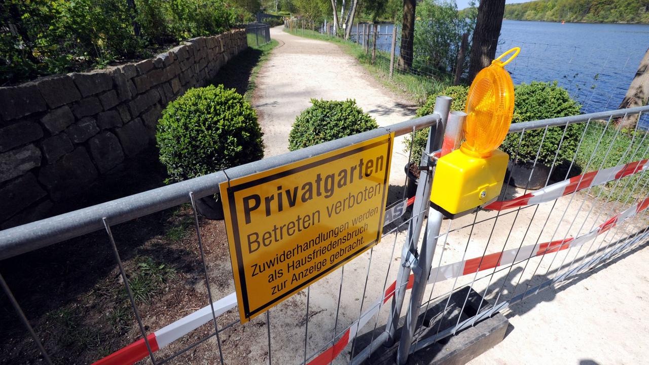 Ein Zaun mit Hinweisschild der Grundstückseigentümer hindert Passanten am Betreten des Uferwegs um den Griebnitzsee in Potsdam Ein Zaun mit Hinweisschild der Grundstückseigentümer hindert Passanten am Betreten des Uferwegs um den Griebnitzsee in Potsdam