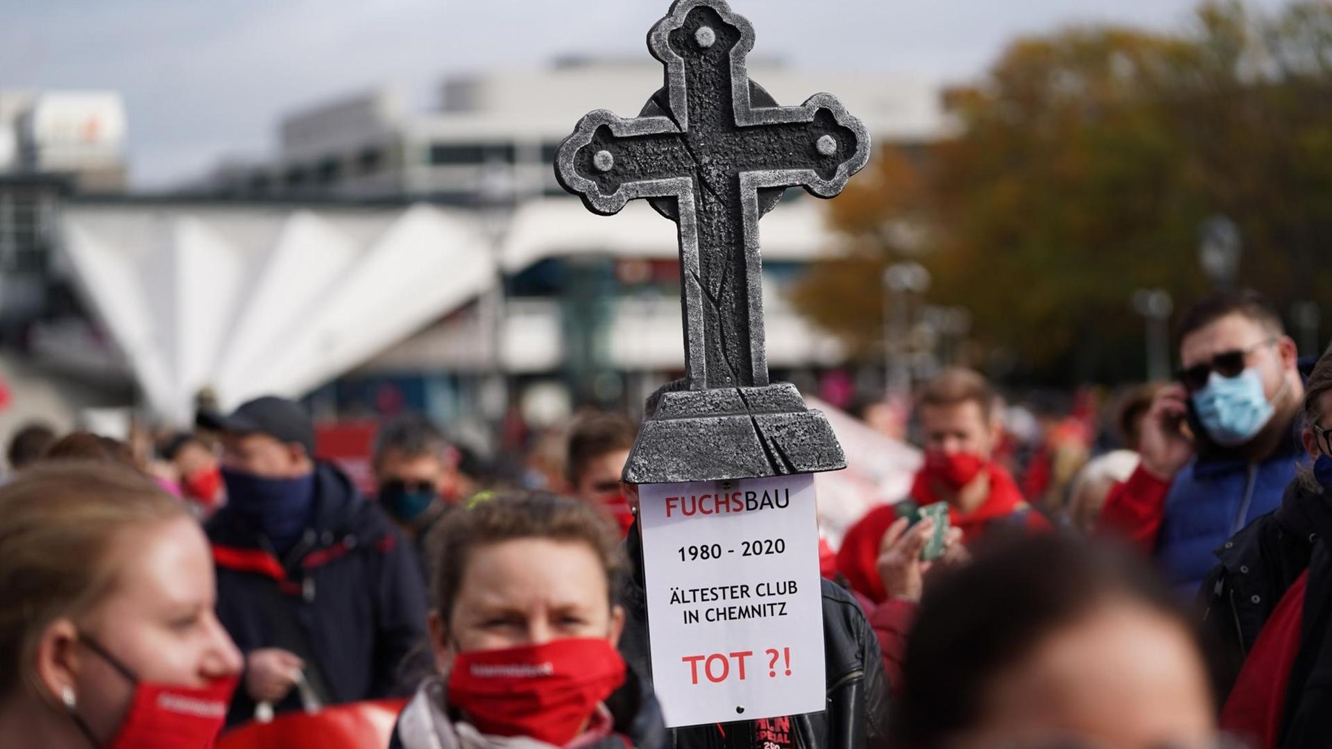 Menschen demonstrieren in Berlin für mehr Kultur trotz Corona. Sie halten ein Kreuz hoch und tragen Mundschutz. Menschen demonstrieren in Berlin für mehr Kultur trotz Corona. Sie halten ein Kreuz hoch und tragen Mundschutz.