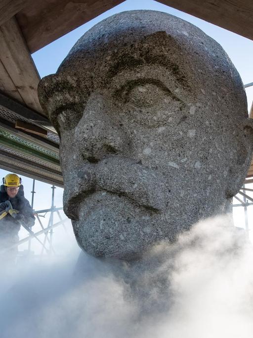 Ein Mann arbeitet mit einem Heißwasser-Hochdruckreinigungsgerät am Kopf des Bismarck-Denkmals.