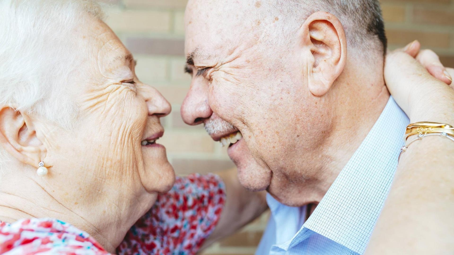 Ein älteres sich anlachendes und umarmendes Paar