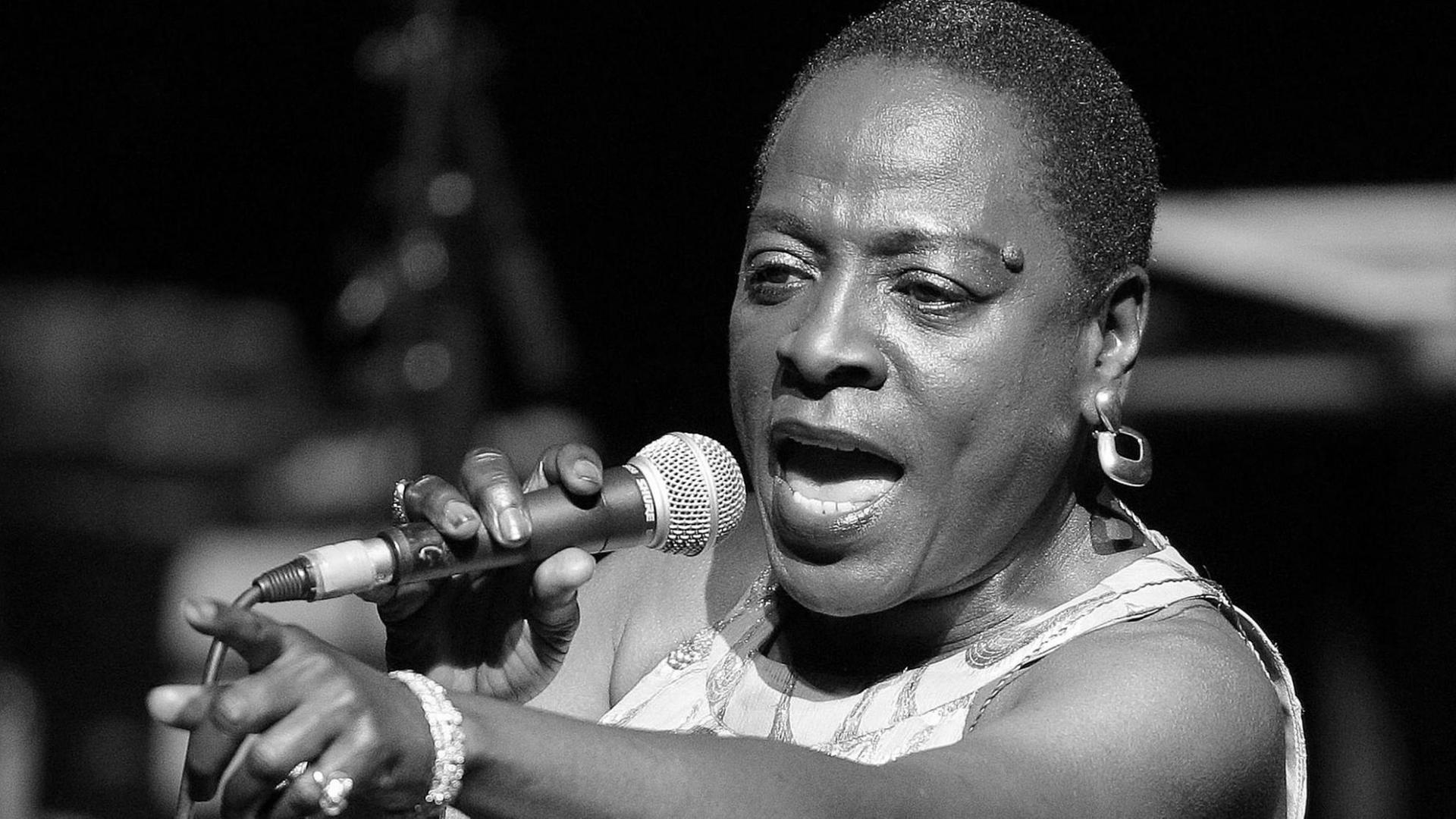 Die Sängerin Sharon Jones mit einem Mikrophon in der Hand bei einem Auftritt im Jahr 2014. Die Sängerin Sharon Jones mit einem Mikrophon in der Hand bei einem Auftritt im Jahr 2014.