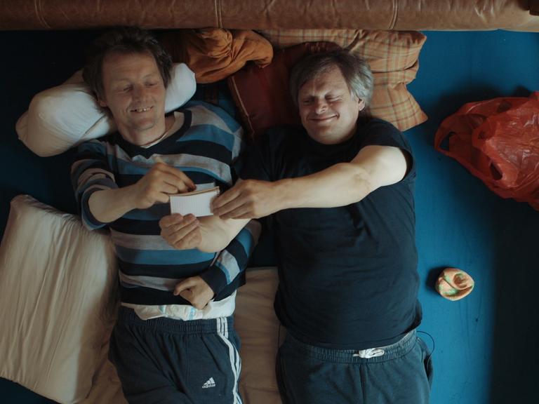 Filmszene aus Bruderliebe: Markus und Michael liegen nebeneinander vergnügt im Bett.